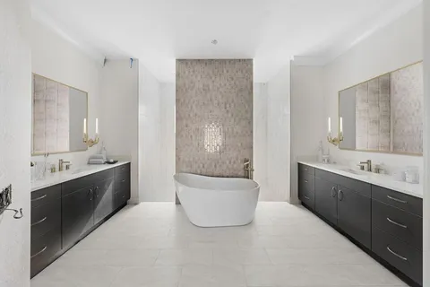 a large bathroom with a double vanity sink mirror and bathtub