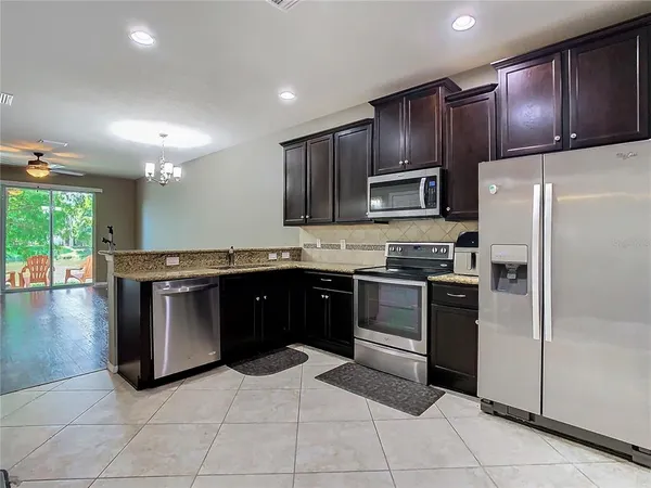 a kitchen with granite countertop stainless steel appliances and a refrigerator