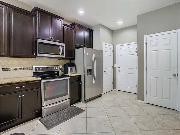 a kitchen with stainless steel appliances granite countertop a refrigerator and a stove top oven