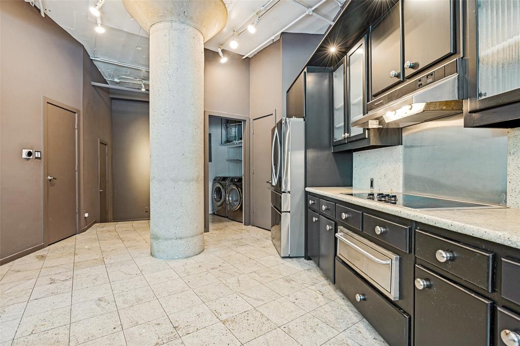 2220 Canton Street, Unit 101 Dallas, TX 75201 - Photo 3 of 20 Kitchen featuring dark cabinetry, stainless steel appliances, and a light-toned countertop