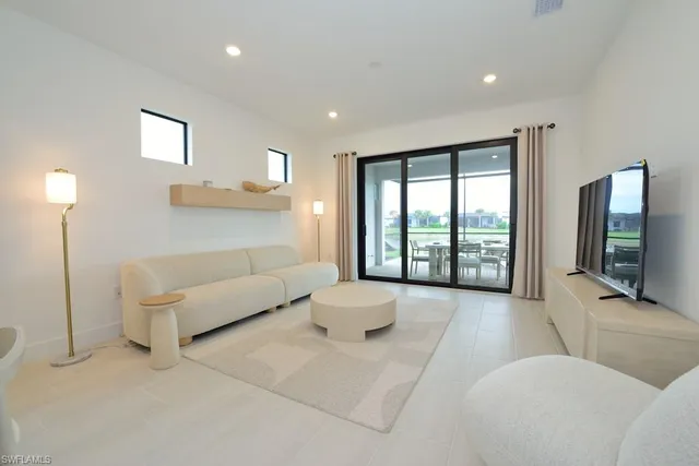 a living room with furniture large window and a flat screen tv