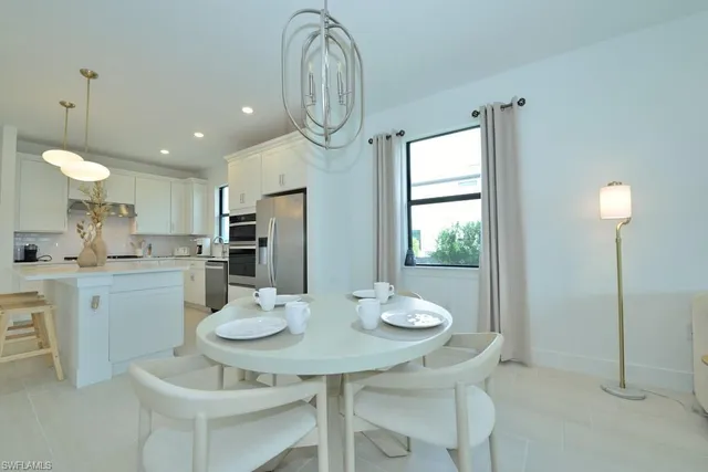 a kitchen with stainless steel appliances kitchen island granite countertop a table and chairs in it