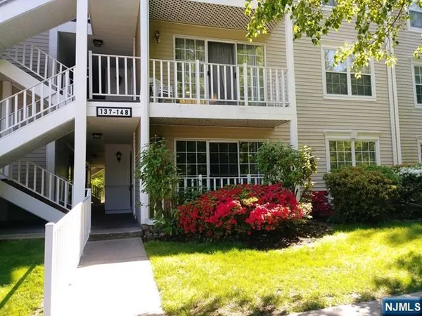 a front view of a house with a yard and a fountain