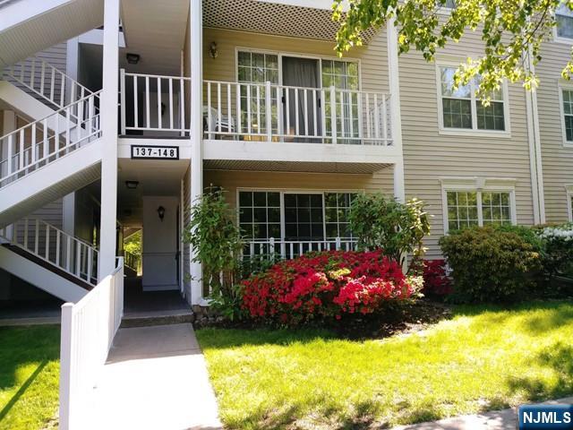 a front view of a house with a yard and a fountain