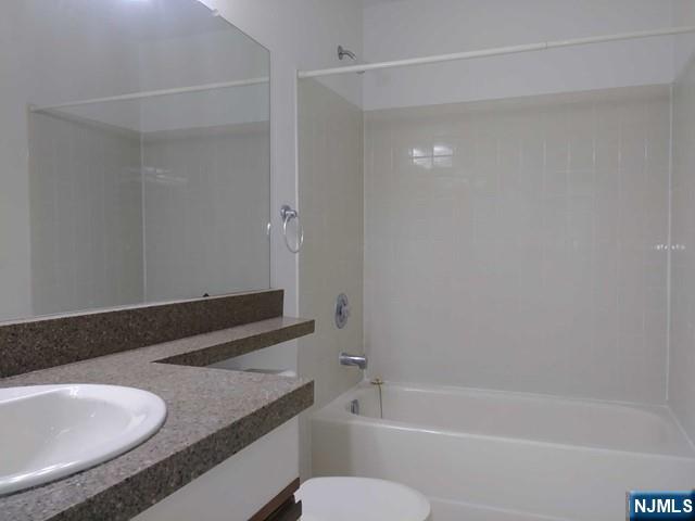 143 Raintree Lane Mahwah, NJ 07430 - Photo 12 of 19 a bathroom with a granite countertop sink a toilet and bathtub