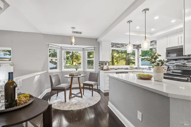 a kitchen with a stove a sink a microwave a dining table and chairs