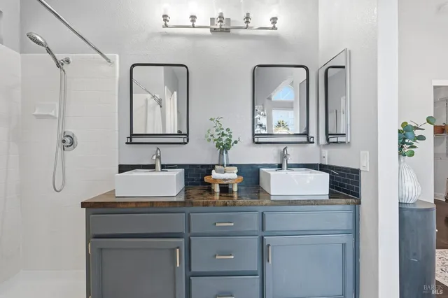 a bathroom with double vanity sinks and a mirror