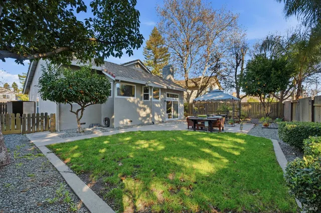 a view of a patio with furniture and a table and chairs under an umbrella
