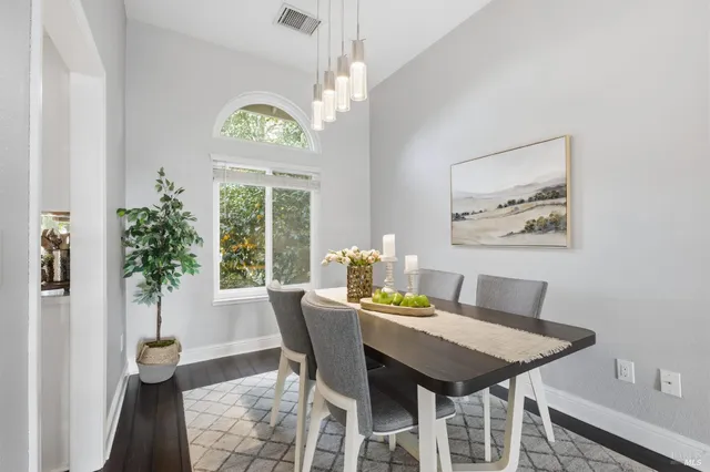 a dining room with furniture potted plants and wooden floor