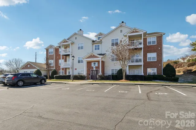 a front view of a building with cars parked