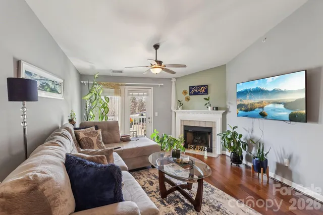 a living room with furniture a fireplace and a flat screen tv