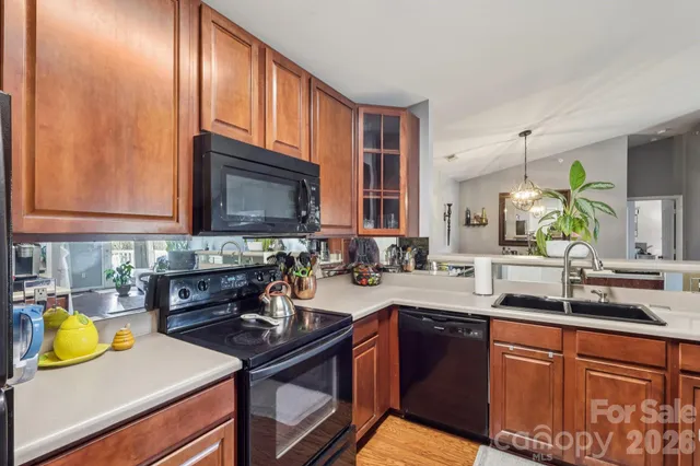 a kitchen with stainless steel appliances granite countertop a sink a stove cabinets and wooden floor