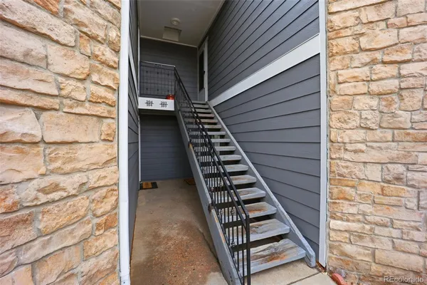 a view of a balcony with stairs and white door
