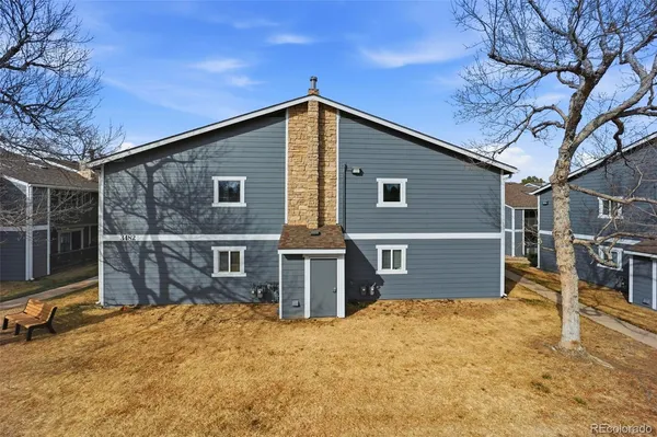a view of a house with a backyard and wooden fence