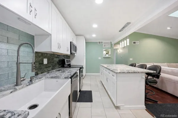 a kitchen with a sink a counter top space cabinets and stainless steel appliances