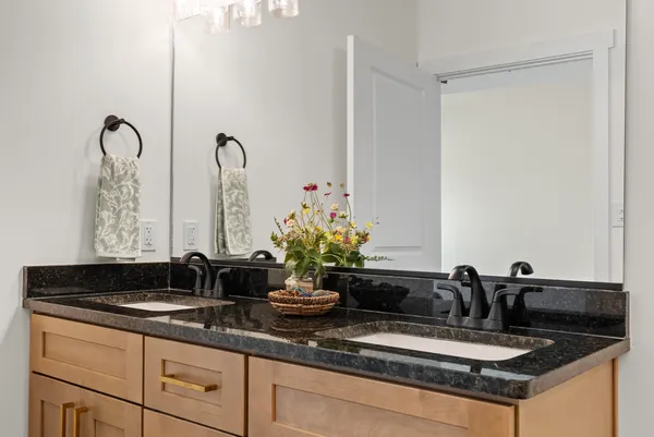 a bathroom with a double vanity sink and a mirror