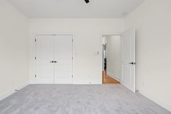 an empty room with a window and a fan