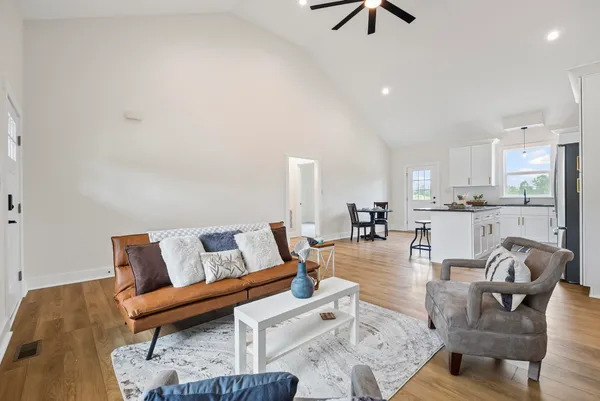 a living room with furniture and a view of kitchen