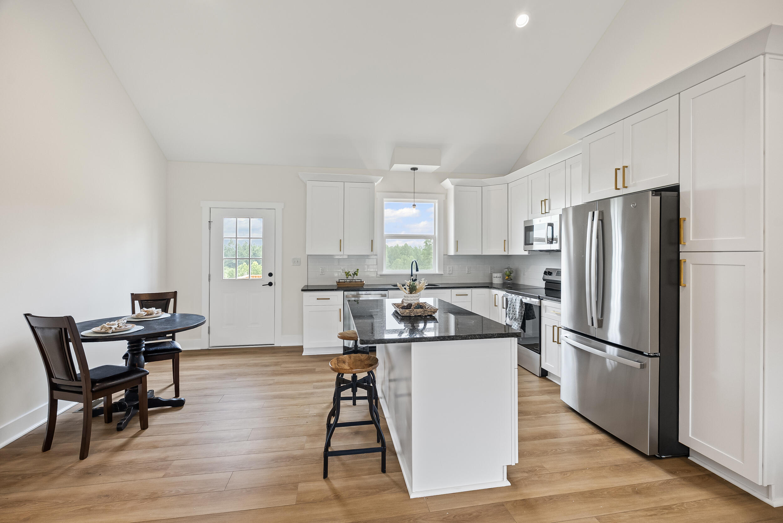 Lot 22 B Scruggs Road Moneta, VA 24121 - Photo 7 of 37 a kitchen with stainless steel appliances granite countertop a refrigerator a stove a sink a dining table and chairs with wooden floor