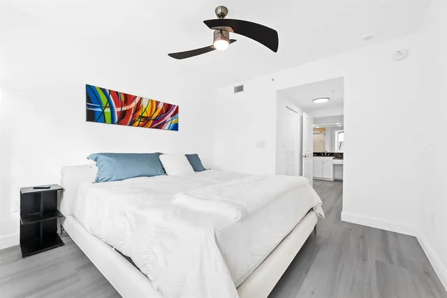 a bedroom with a bed and a painting on the wall