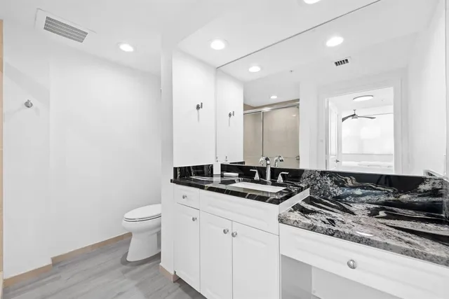 a bathroom with a granite countertop sink and a mirror