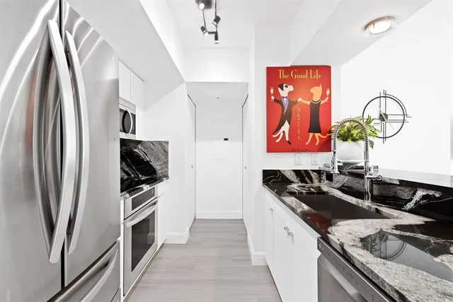 a kitchen with stainless steel appliances granite countertop a sink stove and refrigerator