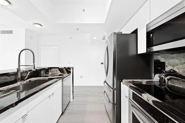 a kitchen with a sink and stainless steel appliances