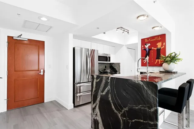 a view of kitchen with stainless steel appliances kitchen island granite countertop a refrigerator and a sink