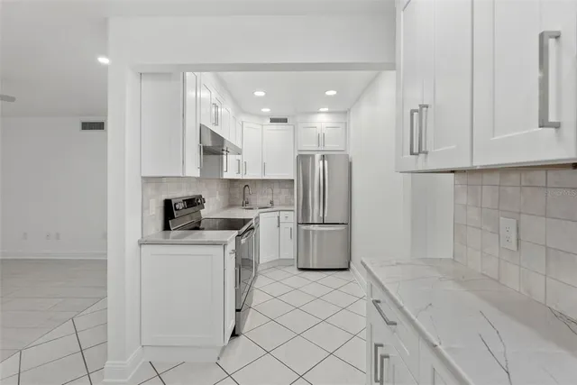 a kitchen with white cabinets and white appliances