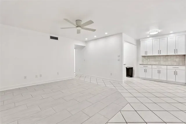 a view of an empty room with kitchen