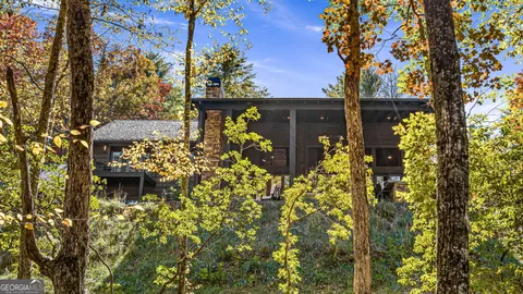 a living room with furniture a fireplace and a floor to ceiling window