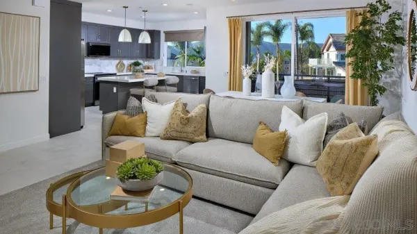 a living room with furniture kitchen view and a large window