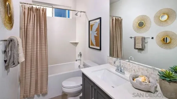 a bathroom with a sink a toilet and shower curtain