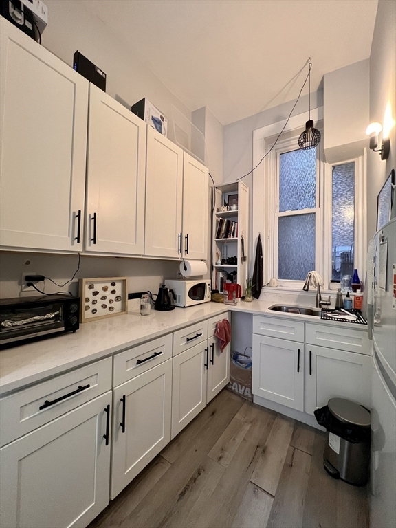83 West Cedar Street, Unit 1 Boston, MA 02114 - Photo 3 of 15 a kitchen with stainless steel appliances granite countertop a sink and cabinets