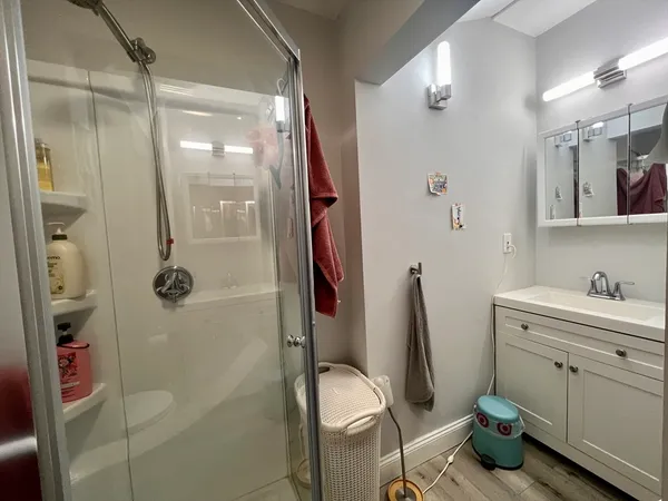 a bathroom with a granite countertop toilet a sink and shower