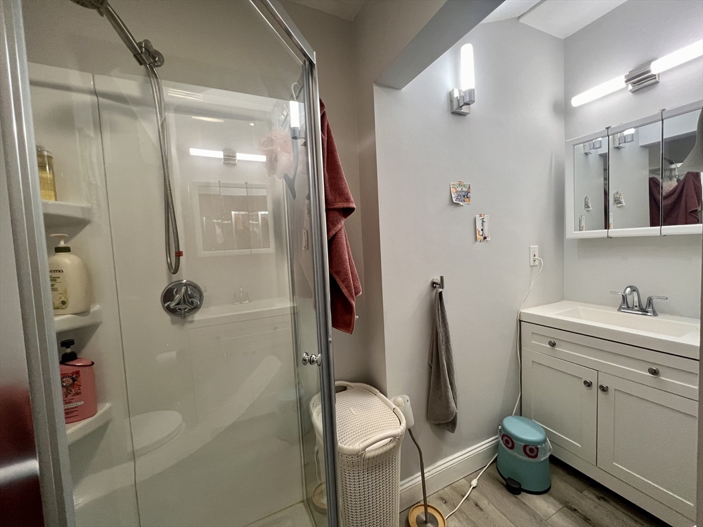 83 West Cedar Street, Unit 1 Boston, MA 02114 - Photo 4 of 15 a bathroom with a granite countertop toilet a sink and shower
