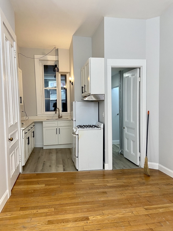 83 West Cedar Street, Unit 1 Boston, MA 02114 - Photo 5 of 15 a view of a kitchen with kitchen island wooden floor and stainless steel appliances