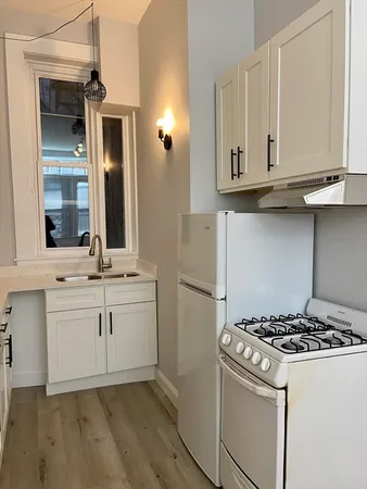 a kitchen with white cabinets and appliances
