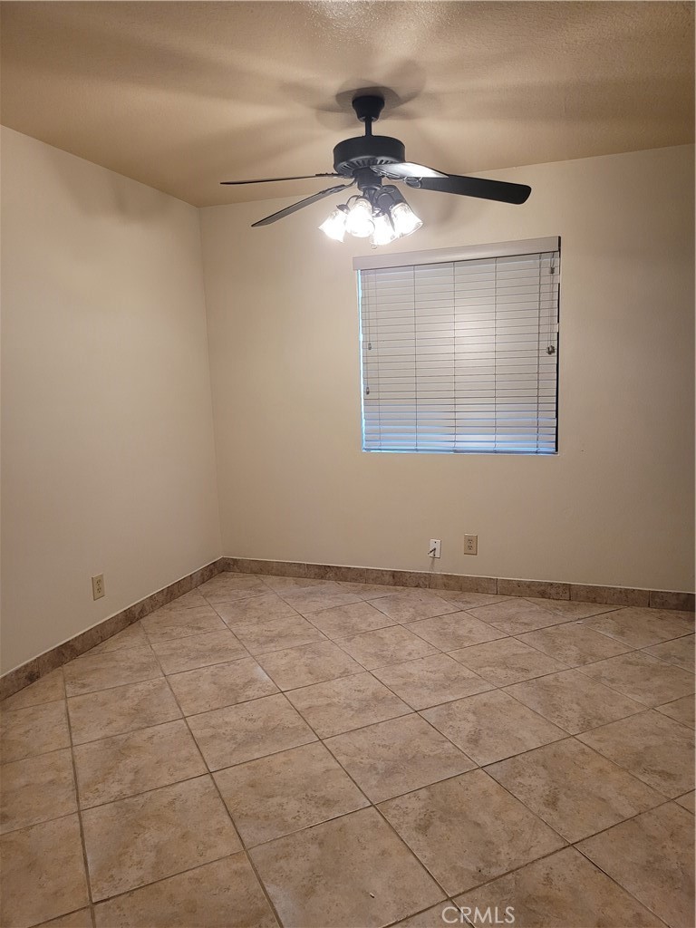 9229 Stewart And Gray Road, Unit D Downey, CA 90241 - Photo 8 of 19 an empty room with a chandelier fan and windows