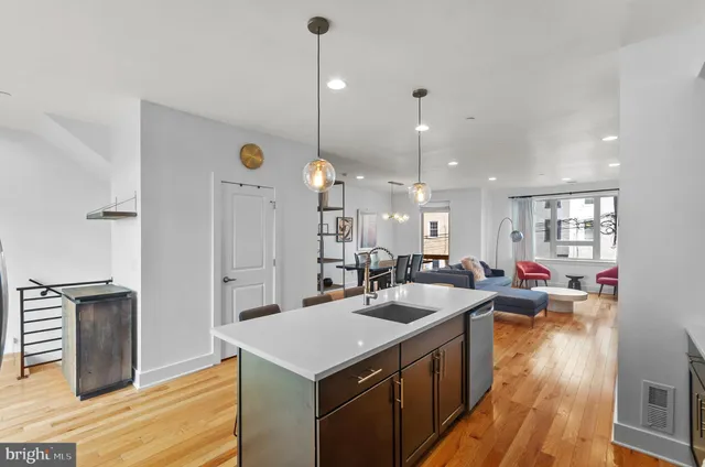 a kitchen with a sink cabinets and wooden floor