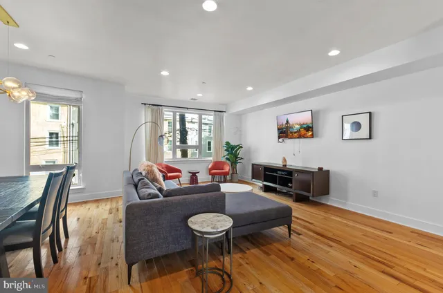 a living room with furniture and a wooden floor