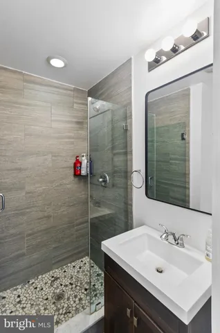 a bathroom with a sink shower and a mirror