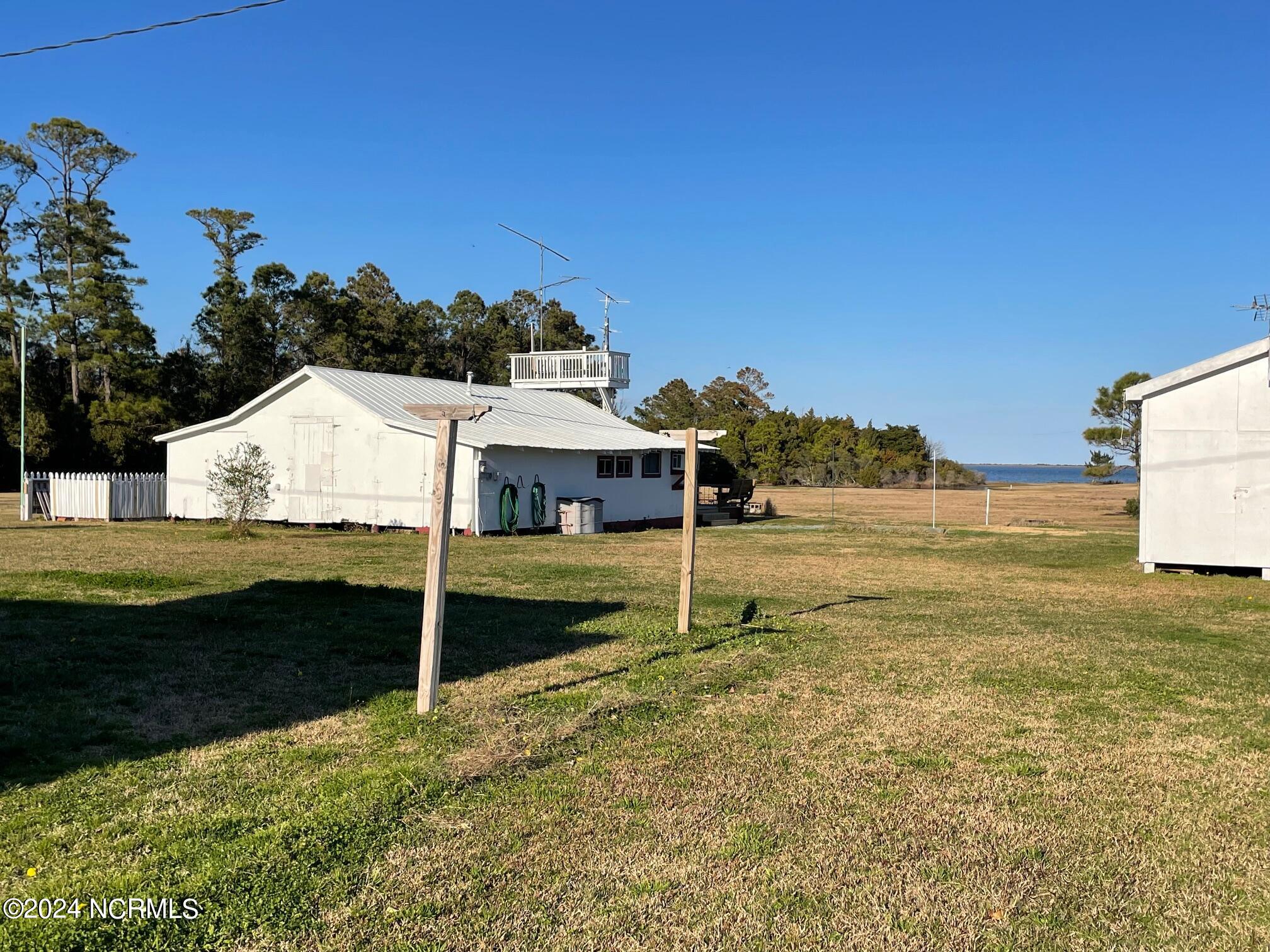 2604 Cedar Island Road Cedar Island, NC 28520 - Photo 44 of 62 Barn and Studio on left, Storage sheds on right.
