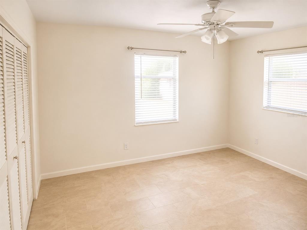 1559 Barry Road Clearwater, FL 33756 - Photo 11 of 20 an empty room with windows and fan