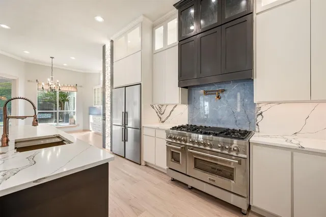 a kitchen with granite countertop a sink stove and refrigerator