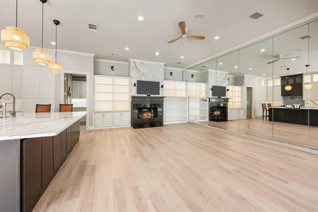 a large kitchen with stainless steel appliances kitchen island granite countertop a large cabinets a sink and a stove