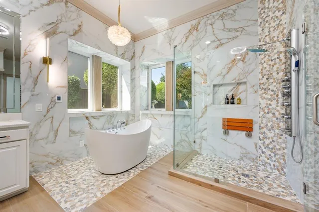 a large white kitchen with a large window a sink and stainless steel appliances