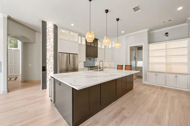 a large kitchen with kitchen island a sink stove and wooden floor