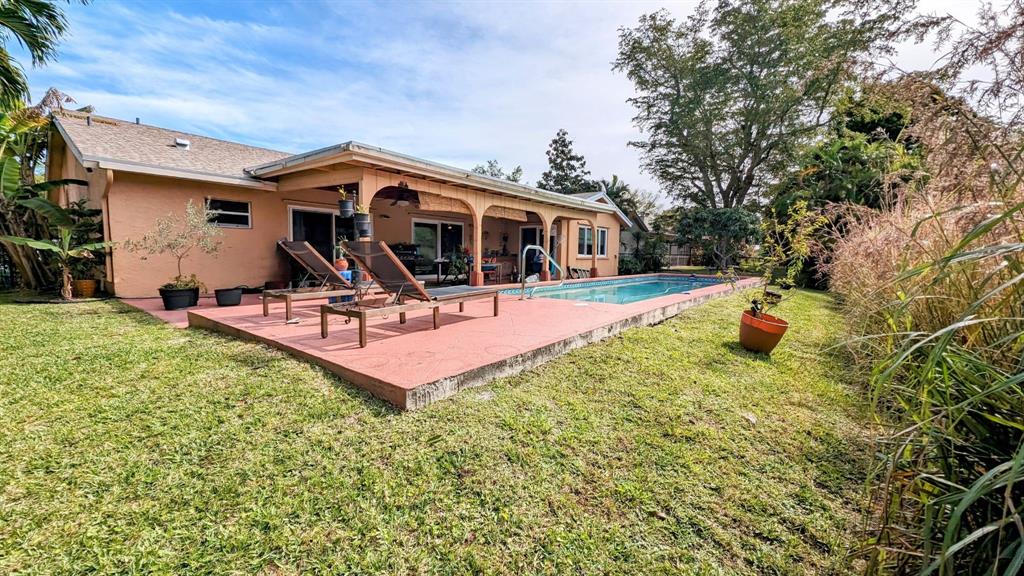 8105 Nutmeg Way Tamarac, FL 33321 - Photo 25 of 28 a backyard of a house with table and chairs