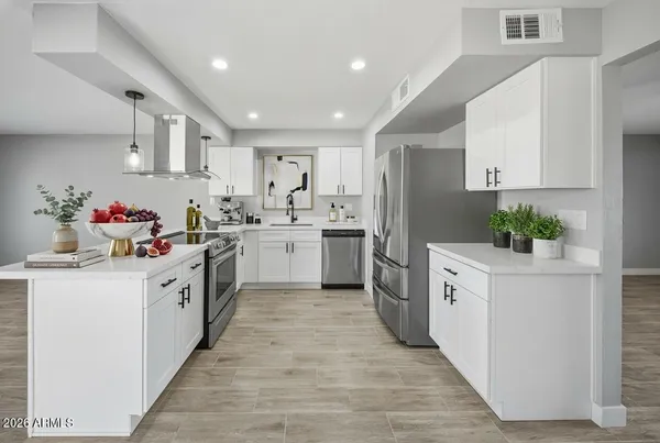 a kitchen with white cabinets stainless steel appliances and sink